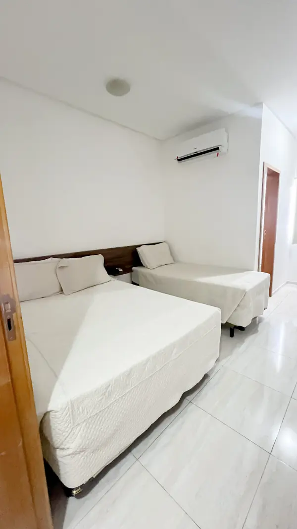 Suíte vista da porta, com cama de casal e cama de solteiro
